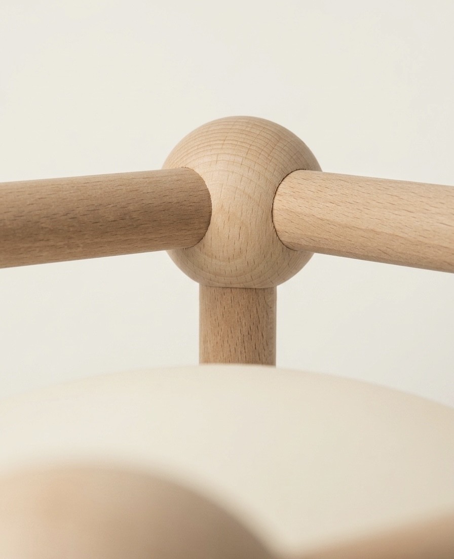 Wooden rods meet in a rounded wooden joint